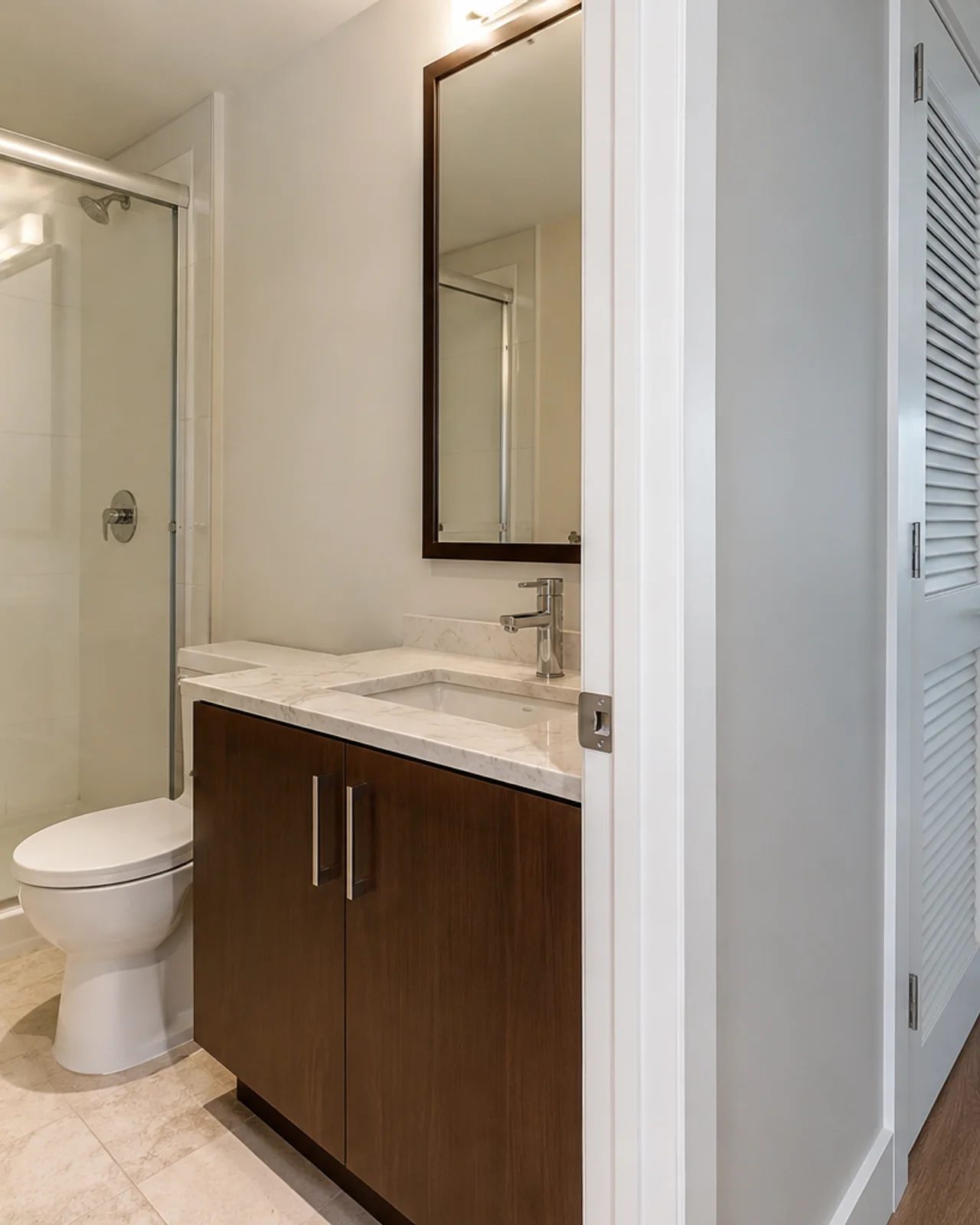 Residential cleaner detailing a bathroom mirror and vanity in a Bellevue home